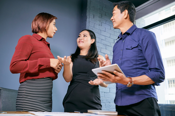 3 orang sedang melakukan diskusi